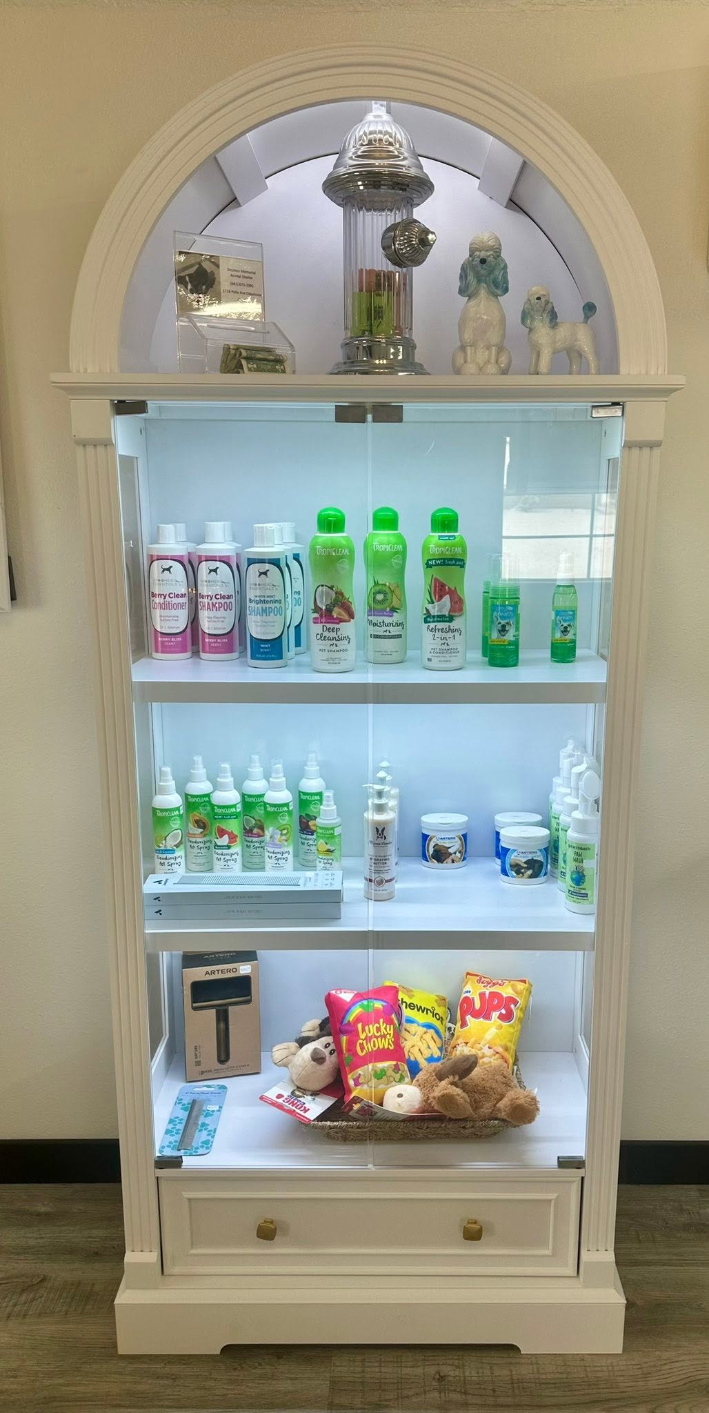 Retail cabinet stocked with pet shampoos, sprays, and treats at Whitney's Paw Spa